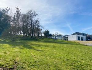 a grassy field with trees and a building at Villa Do Retiro in Dumbría