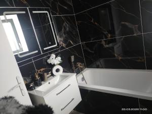 a bathroom with a white sink and a bath tub at Le T3 Élégance Lyon aéroport in Janneyrias +11 photos