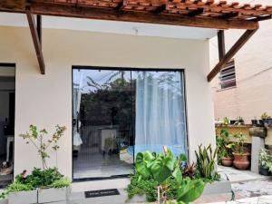 a house with a glass door in a garden at Residencial Costa Loft in Angra dos Reis