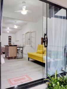 a living room with a yellow couch and a table at Residencial Costa Loft in Angra dos Reis
