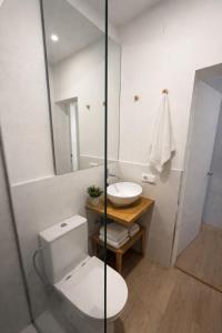 a bathroom with a toilet and a sink and a mirror at 31CaL QuEROL Boutique centre Puigcerdà in Puigcerdà
