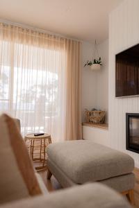 a bedroom with a bed and a couch and a window at Bay Days - Binalong Bay in Binalong Bay