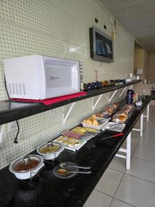 a buffet line with plates of food on a counter at Yves Hotel in Porto Velho