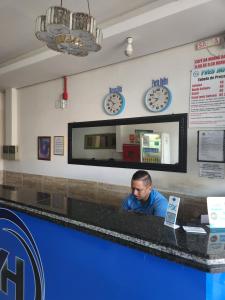 a man sitting at a counter in a fast food restaurant at Yves Hotel in Porto Velho