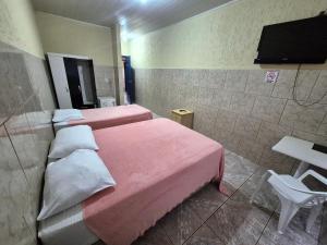 a room with two beds and a television in it at Yves Hotel in Porto Velho