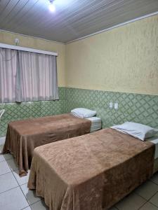 two beds in a room with green walls at Yves Hotel in Porto Velho +71 photos