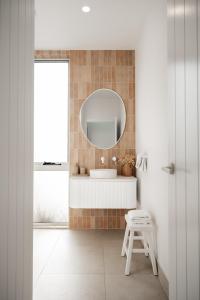 a bathroom with a white sink and a mirror at Bay Days - Binalong Bay in Binalong Bay +15 photos