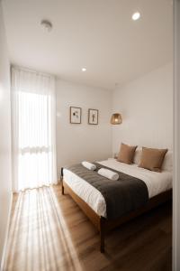 a bedroom with a large bed and a window at Bay Days - Binalong Bay in Binalong Bay