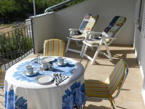 a table and chairs sitting on a balcony with a table at Apartment in Malinska I in Sveti Vid-Miholjice