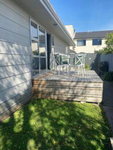 a house with a deck with a table and chairs on it at The Park Cottage in Napier