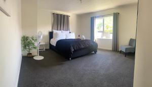 a bedroom with a bed and a window at The Park Cottage in Napier
