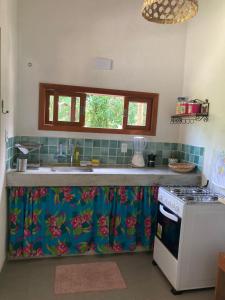a kitchen with a sink and a stove top oven at Casa Filtro Morere in Cairu