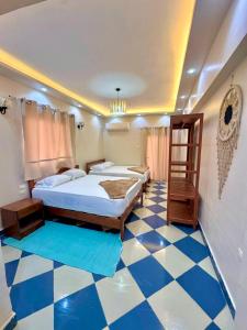 a bedroom with two beds and a checkered floor at Saray Hotel Dahab in Dahab