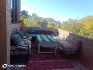 a balcony with couches and a table and a window at Gite souran in Imlil