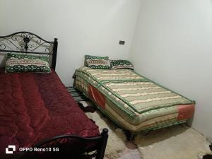two beds sitting next to each other in a bedroom at Gite souran in Imlil