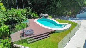 a swimming pool in a yard with a deck at Rainforest Escape with Pool & Mountain Views in Caravonica