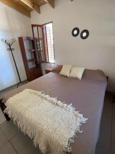 a bedroom with a large bed with a rug on it at Cabaña Lazarillo in Amaicha del Valle