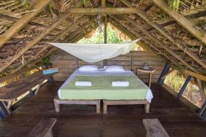 a bedroom with a hammock in a wooden cabin at El Vijo Surf in Nuquí