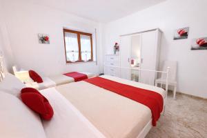 a white bedroom with two beds and a chair at Casa Sant'Antonio in Bari