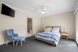 a bedroom with a bed and a blue chair at Bay Breeze in Cowes