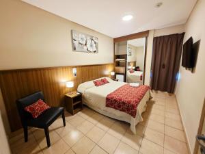 a hotel room with a bed and a chair at Hotel Confianza in Corrientes