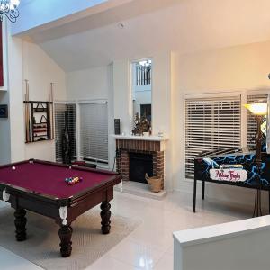 a living room with a pool table and a fireplace at Stunning Absolute Waterfront With Private Jetty in Fishing Point