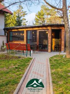 a log cabin with a bench and a house at Holiday Home Zelena Oaza in Sarajevo