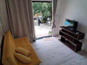 a living room with a couch and a television at Residencial Costa Loft in Angra dos Reis