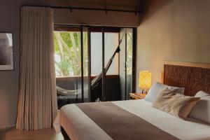 a bedroom with a bed and a large window at Sui Boutique Hotel in Medellín