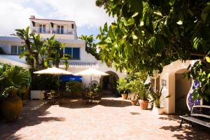 a patio with chairs and umbrellas in front of a building at Central Park Terme in Ischia