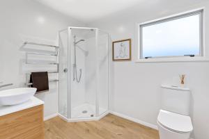 a bathroom with a shower and a sink at The Bach - Pohara in Pohara +4 photos