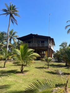 a house on the beach with palm trees at Cabaña Olas del Viento 1 in San Bernardo del Viento