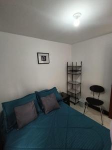 a bedroom with a blue bed and a table at Hospedaje Donde Jaime-Choachí in Choachí