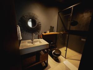 a bathroom with a sink and a mirror and a toilet at Sui Boutique Hotel in Medellín +89 photos