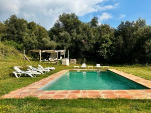 a swimming pool with a group of chairs and a tent at Can Petitu in Amer