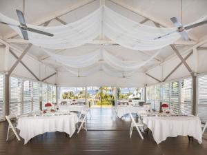 a marquee with white tables and chairs and white drapes at Mercure Townsville in Townsville +93 photos