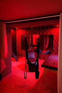 a red room with a chair and a couch at Paradise Room - Spa & Sauna de Luxe à Yutz in Basse-Yutz