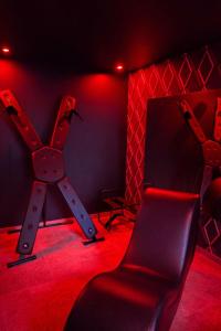 a red room with a chair and a mirror at Paradise Room - Spa & Sauna de Luxe à Yutz in Basse-Yutz