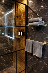 a bathroom with a glass shower stall with towels at Paradise Room - Spa & Sauna de Luxe à Yutz in Basse-Yutz +29 photos