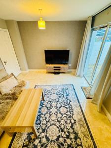 a living room with a flat screen tv and a table at The King's Imperial Suite in Drogheda