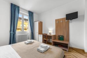 a bedroom with a bed and a desk and a television at Casa Diego, Colico Centro Living in Colico