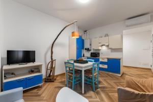 a kitchen with blue cabinets and a table with chairs at Casa Diego, Colico Centro Living in Colico