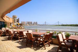 a row of tables and chairs next to a river at Nile Trans Hotel in Cairo