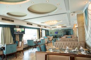 a dining room with tables and chairs and a restaurant at Nile Trans Hotel in Cairo