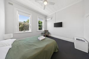 a bedroom with a bed and a flat screen tv at The Oriental Hotel in Newcastle