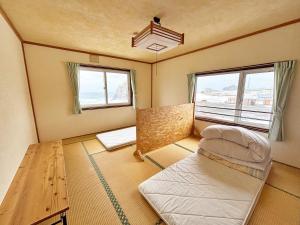 a bedroom with a bed and two windows at Rishiri Greenhill Inn in Oshidomari