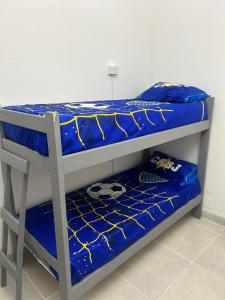 a bunk bed with a blue comforter on it at Viví el mundo Boca en el HOSTEL DEL 10 in Buenos Aires
