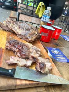 a cutting board with meat and a knife on a table at Viví el mundo Boca en el HOSTEL DEL 10 in Buenos Aires