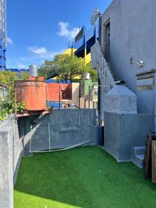 a balcony with green grass on the side of a building at Viví el mundo Boca en el HOSTEL DEL 10 in Buenos Aires