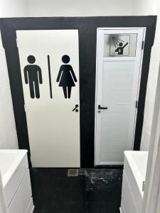 a bathroom with two white doors with signs on them at Viví el mundo Boca en el HOSTEL DEL 10 in Buenos Aires +15 photos